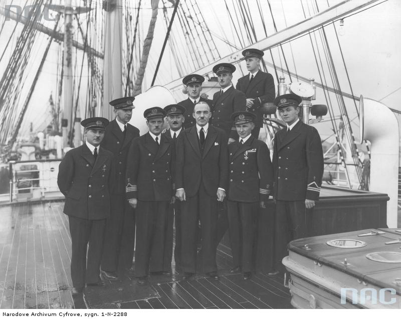 Poseł nadzwyczajny i minister pełnomocny Polski w Japonii Michał Mościcki w otoczeniu oficerów na pokładzie \"Daru Pomorza\". Stoją od lewej: IV oficer Stanisław Kosko, lekarz dr Jarosław Truszkowski, kapitan statku Konstanty Maciejewicz, radiotelegrafista Alojzy Kwiatkowski, minister Michał Mościcki, I oficer Tadeusz Meissner, kapelan ks. Wojciech Główczewski. Stoją za nimi od lewej: III oficer Stanisław Rowiński, II oficer Konstanty Kowalski, V oficer Stefan Gorazdowski.