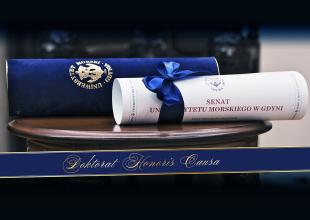 Dyplom DHC zwinięty w rolkę leżący na stoliku